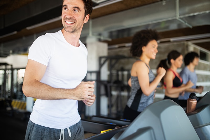 Happy group of fit people training in gym