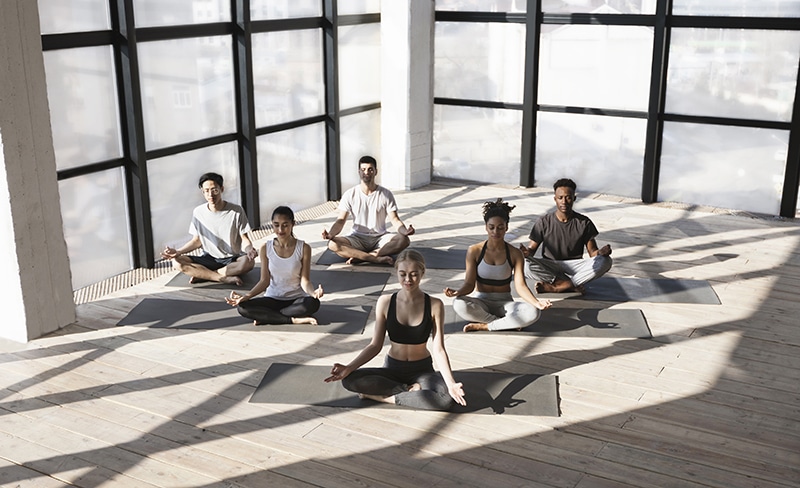 Group Of People Sitting In Lotus Position, Making Meditation Exercises