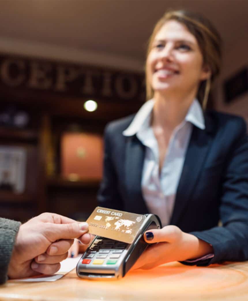 guest paying at hotel checkout on a credit card terminal