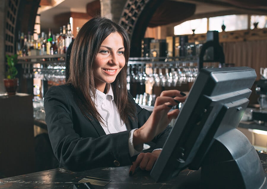 waiter at the bar using the POS System for customer checkout