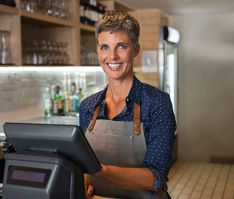 Business owner using POS system installed with zero fee credit card processing program