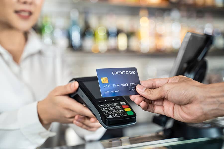 Customer at the checkout paying with credit card on the payment terminal